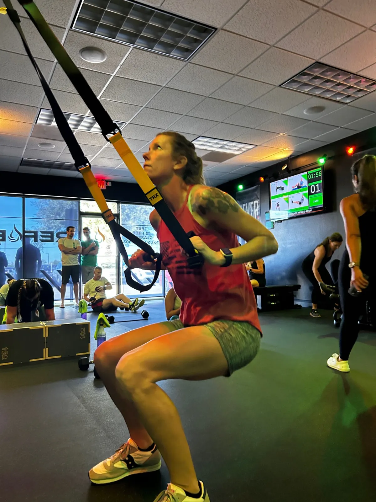 Member performing a TRX squat during a bootcamp class